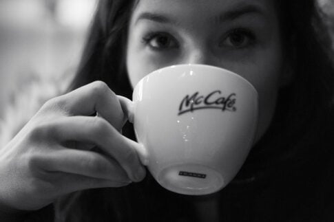 What kind of coffee does McDonald's use, girl drinking a cup of McCafe