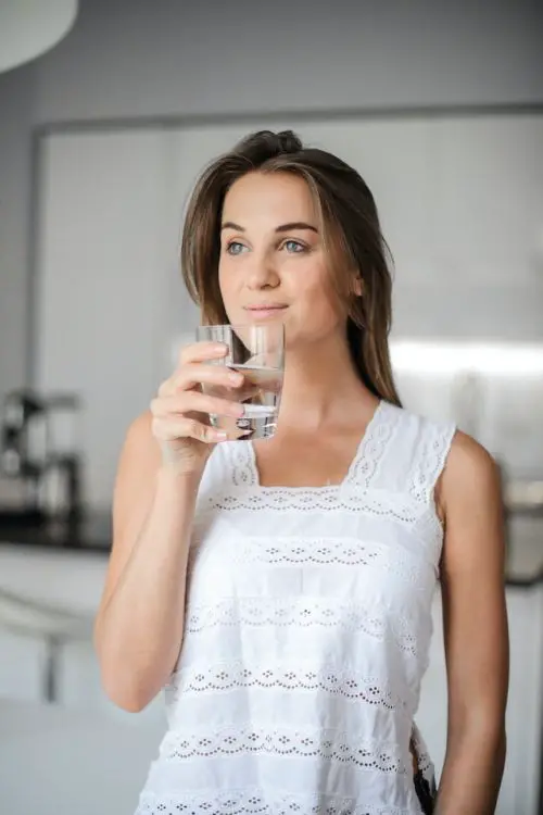 Can You Drink Coffee With Invisalign, a woman drinking a cup of water