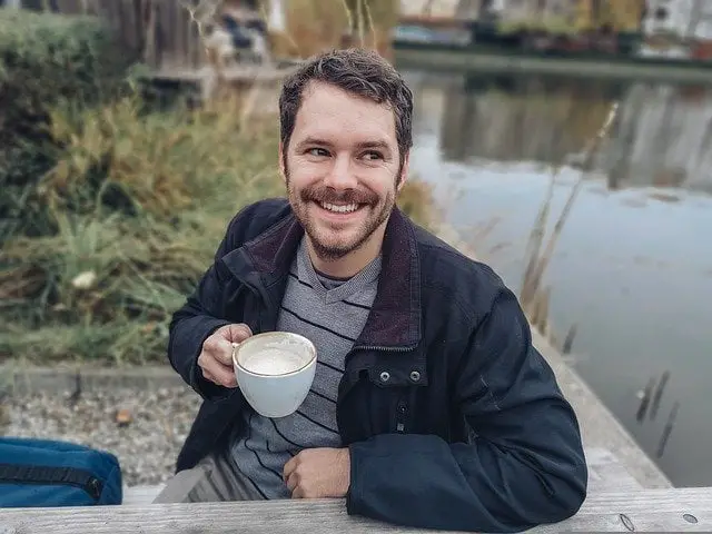 Top benefits of caffeine, a happy man enjoying a cup of Joe